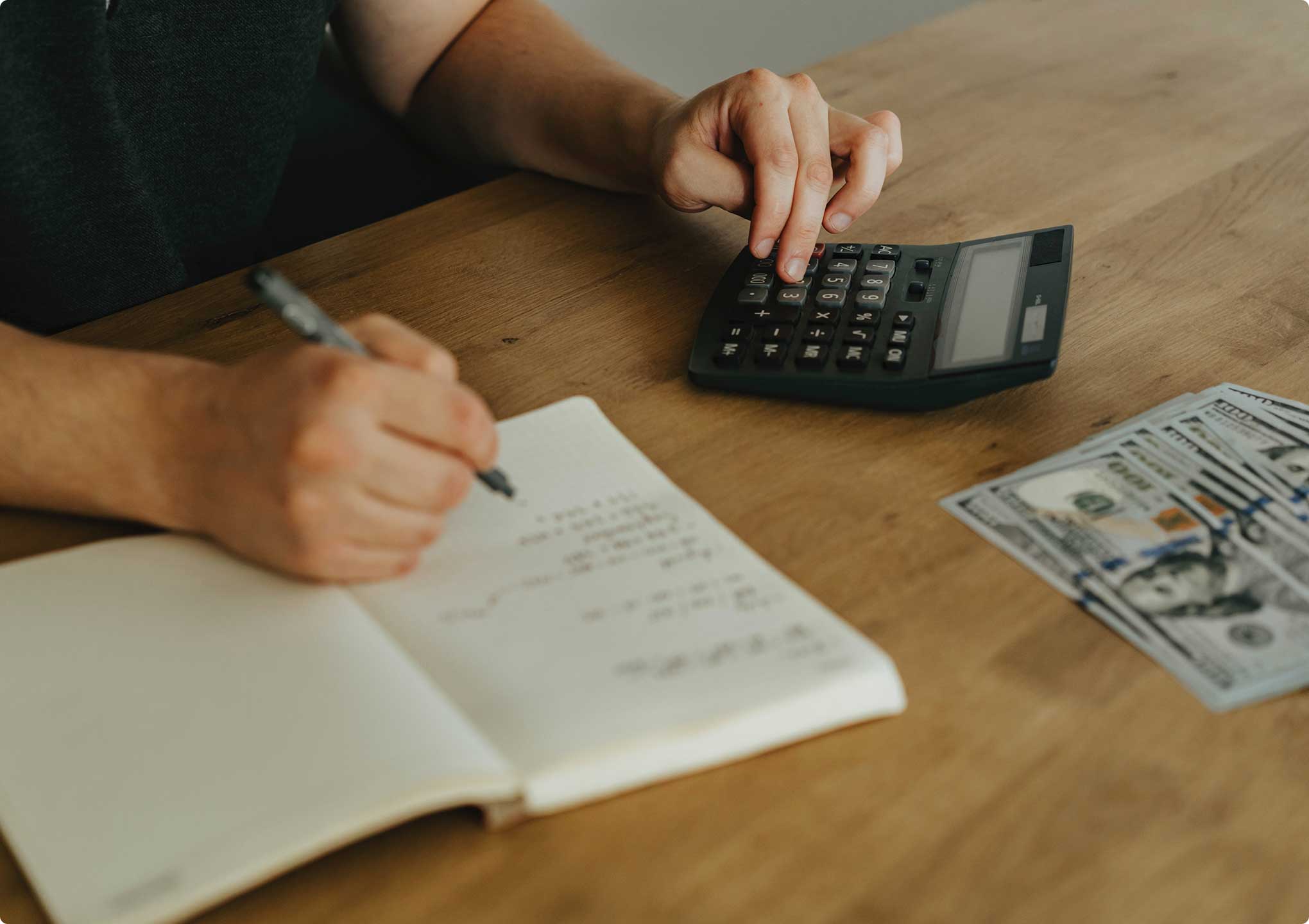 blog-post-new-4 hands typing on a calculator and writing in a journal