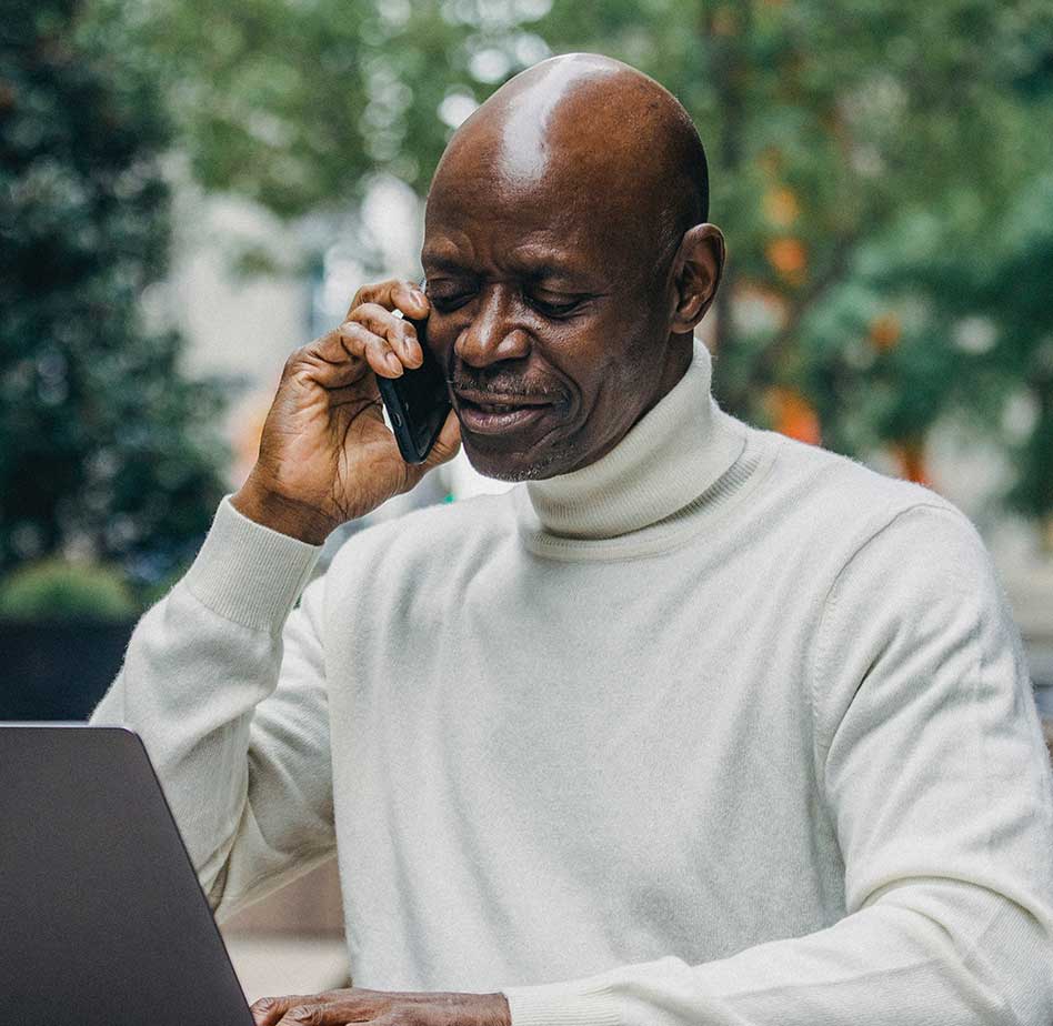 ac-testimonial-4 african american man on the telephone looking at laptop
